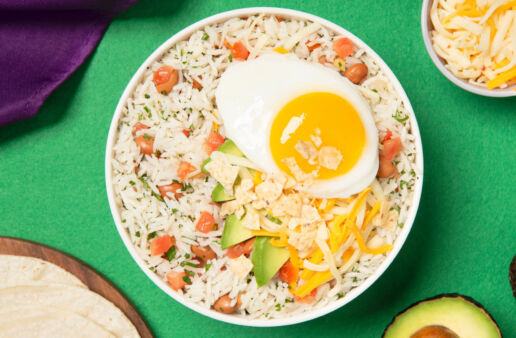 Huevos rancheros rice bowl con tomatoes, aguacate y arroz listo para servir