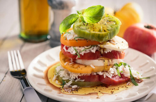 Layered rice caprese salad with tomatoes, mozzarella and basil