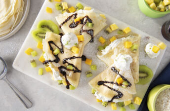 rice-crepes-with-kiwi-pineapples-mango-coconut-whipped-cream-and-chocolate-syrup